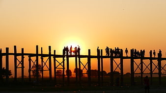 Silhouette of people on U Bein Bridge at sunset