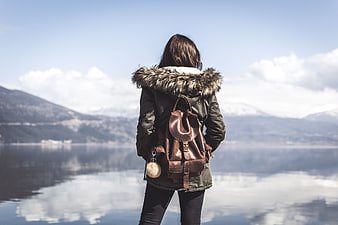 Woman with Backpack Looking at Lake and Mountains