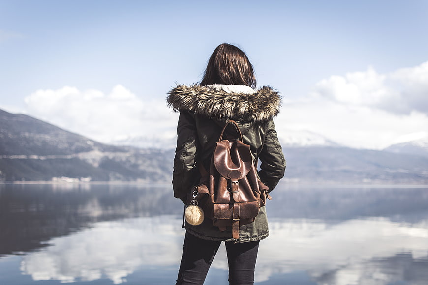 Woman with Backpack Looking at Lake and Mountains