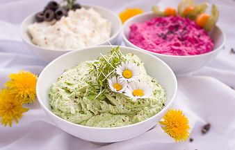 Three bowls of colorful cream cheese dips with flowers