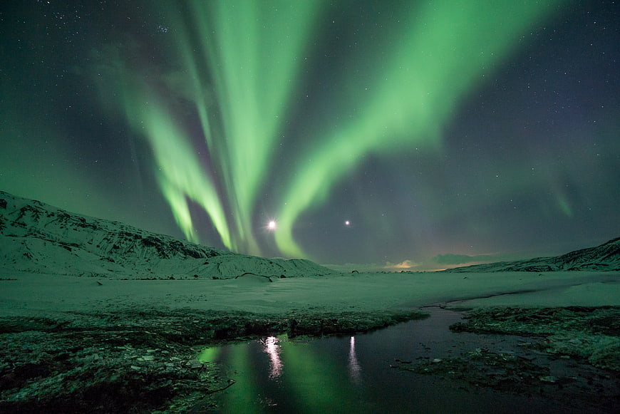 Vibrant Green Aurora Borealis Over Snowy Winter Landscape