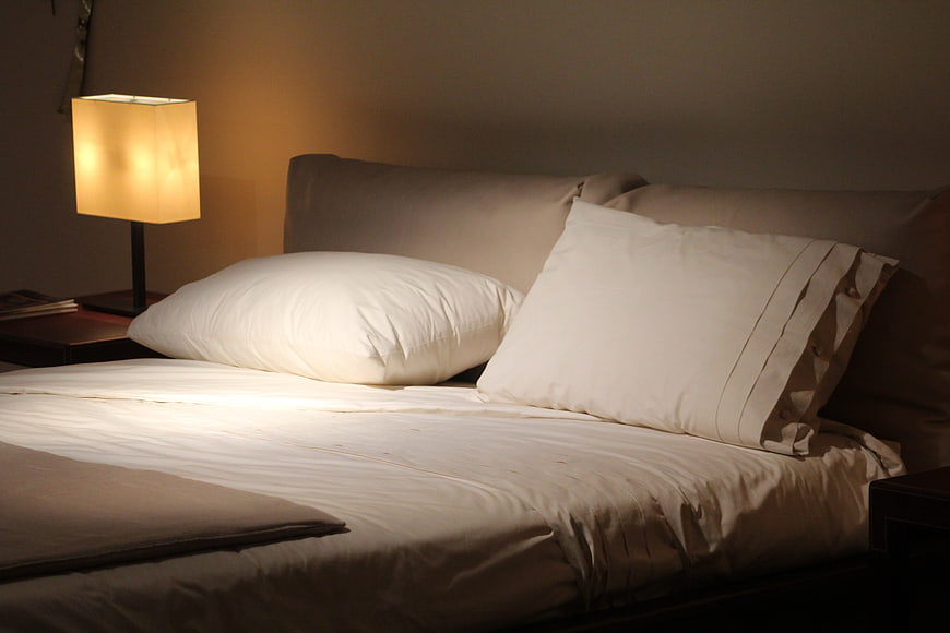 Cozy Bedroom with Warm Lamp Light and White Bedding