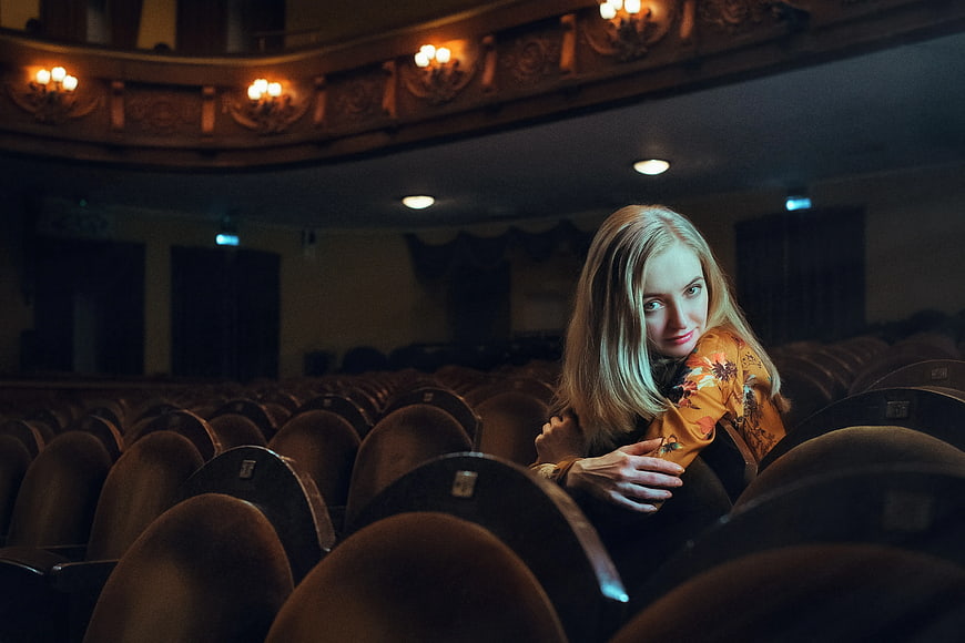 Blonde Woman in Empty Theater Auditorium