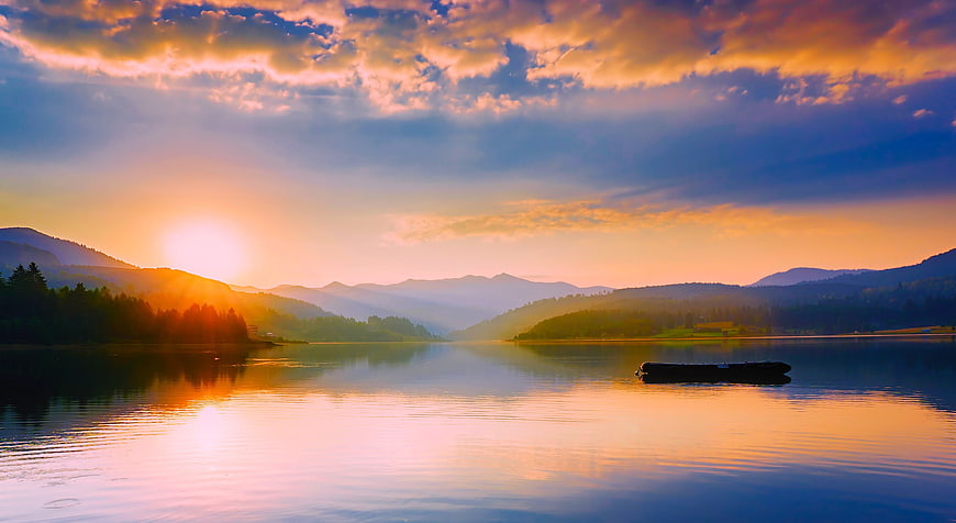Serene Lake Sunset with Mountains and Raft Reflection