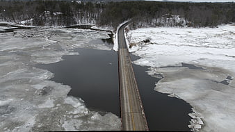 Aerial view of bridge over frozen river in winter