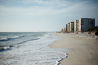 Wide Beach View with Ocean Waves and Coastal Hotels