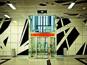Modern glass elevator in geometric patterned lobby