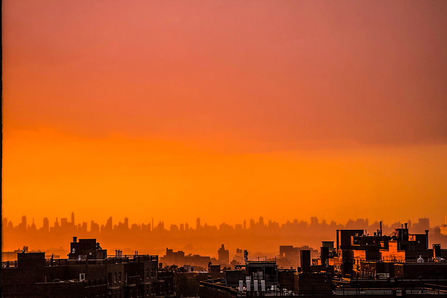 Vibrant Orange Sunset Over Urban City Skyline