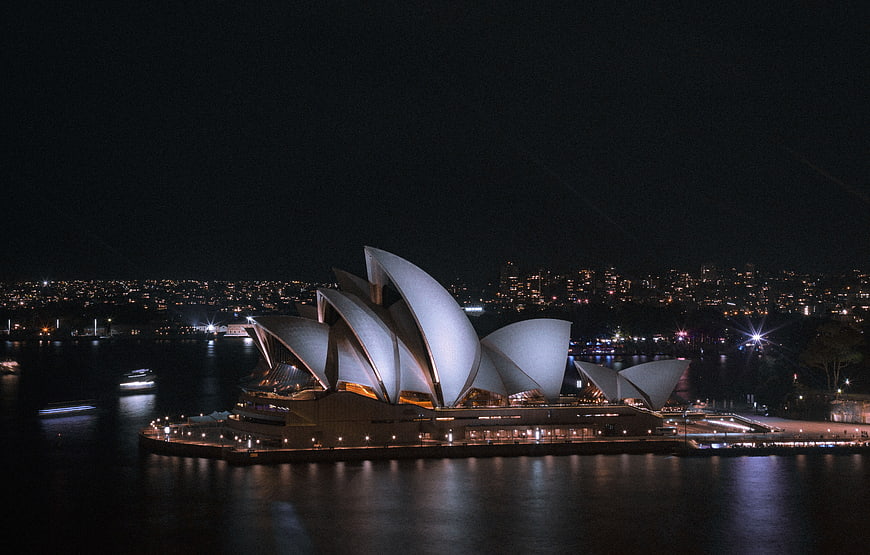 Sydney Opera House illuminated at night with city skyline