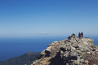 Hikers on Rocky Mountain Peak Overlooking Ocean