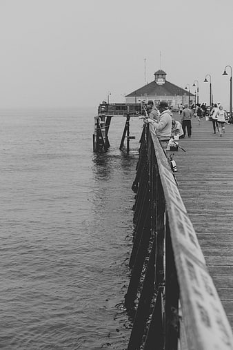 Black and white photo of fishermen on a pier