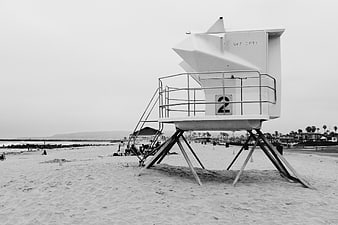 Black and white lifeguard tower on sandy beach