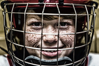 Close-up of smiling boy with freckles in football helmet