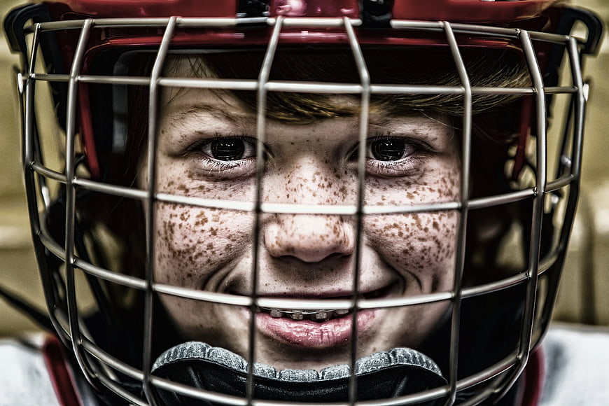 Close-up of smiling boy with freckles in football helmet