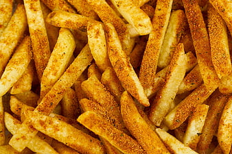 Close-up of seasoned golden french fries with spices