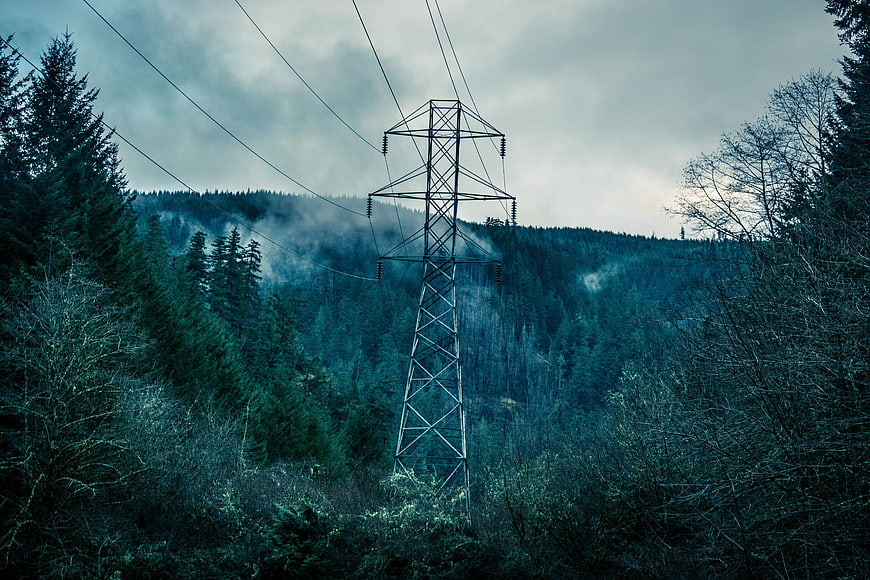 High Voltage Power Line Tower in Misty Forest
