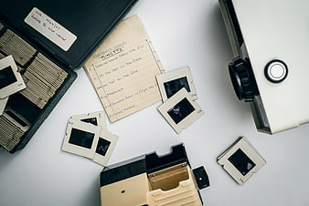 Vintage slide film strips and projector on white background