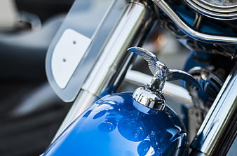 Close-up of Blue Motorcycle Tank with Chrome Eagle Emblem