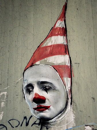 Melancholic Clown Street Art Mural on Cracked Concrete Wall