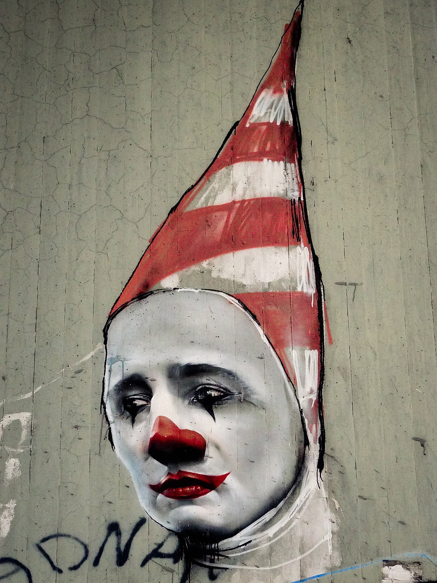 Melancholic Clown Street Art Mural on Cracked Concrete Wall