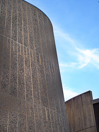 Curved granite building facade against blue sky