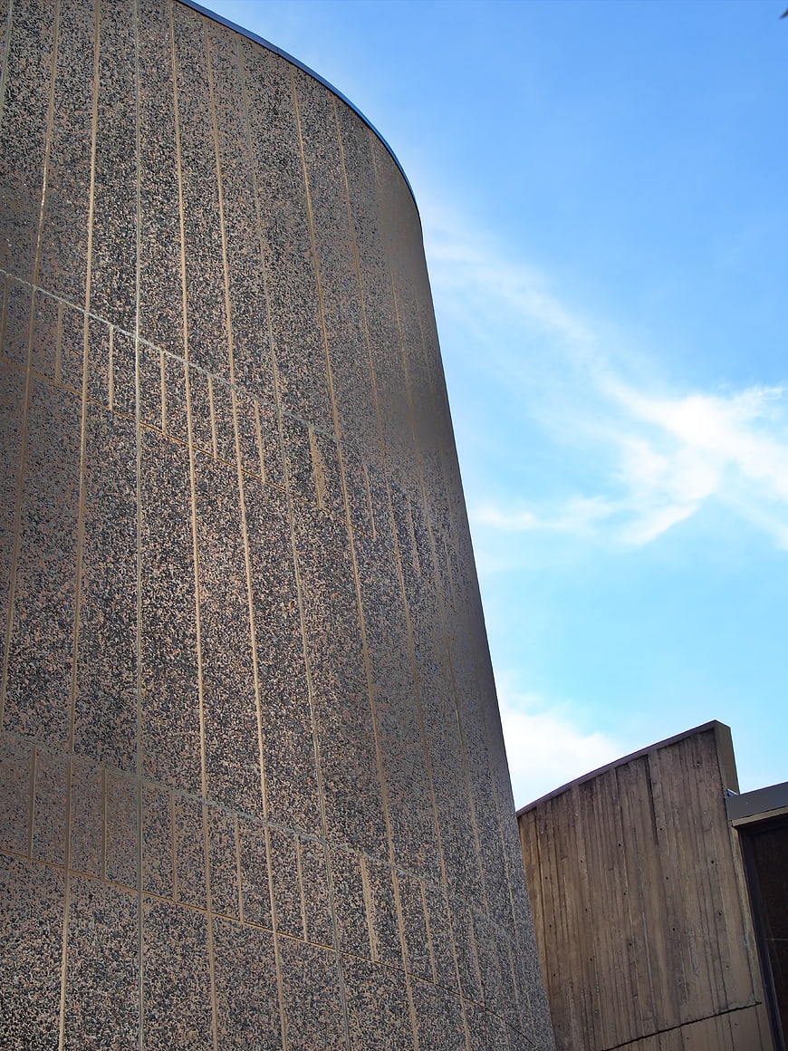 Curved granite building facade against blue sky