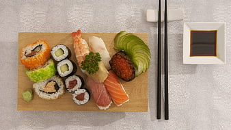 Overhead view of assorted sushi platter with soy sauce and chopsticks