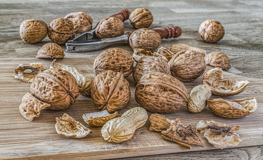 Walnuts and Nutcracker on Wooden Board