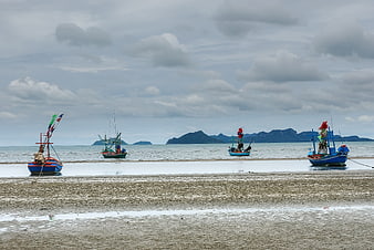 Colorful Fishing Boats on Muddy Beach with Islands