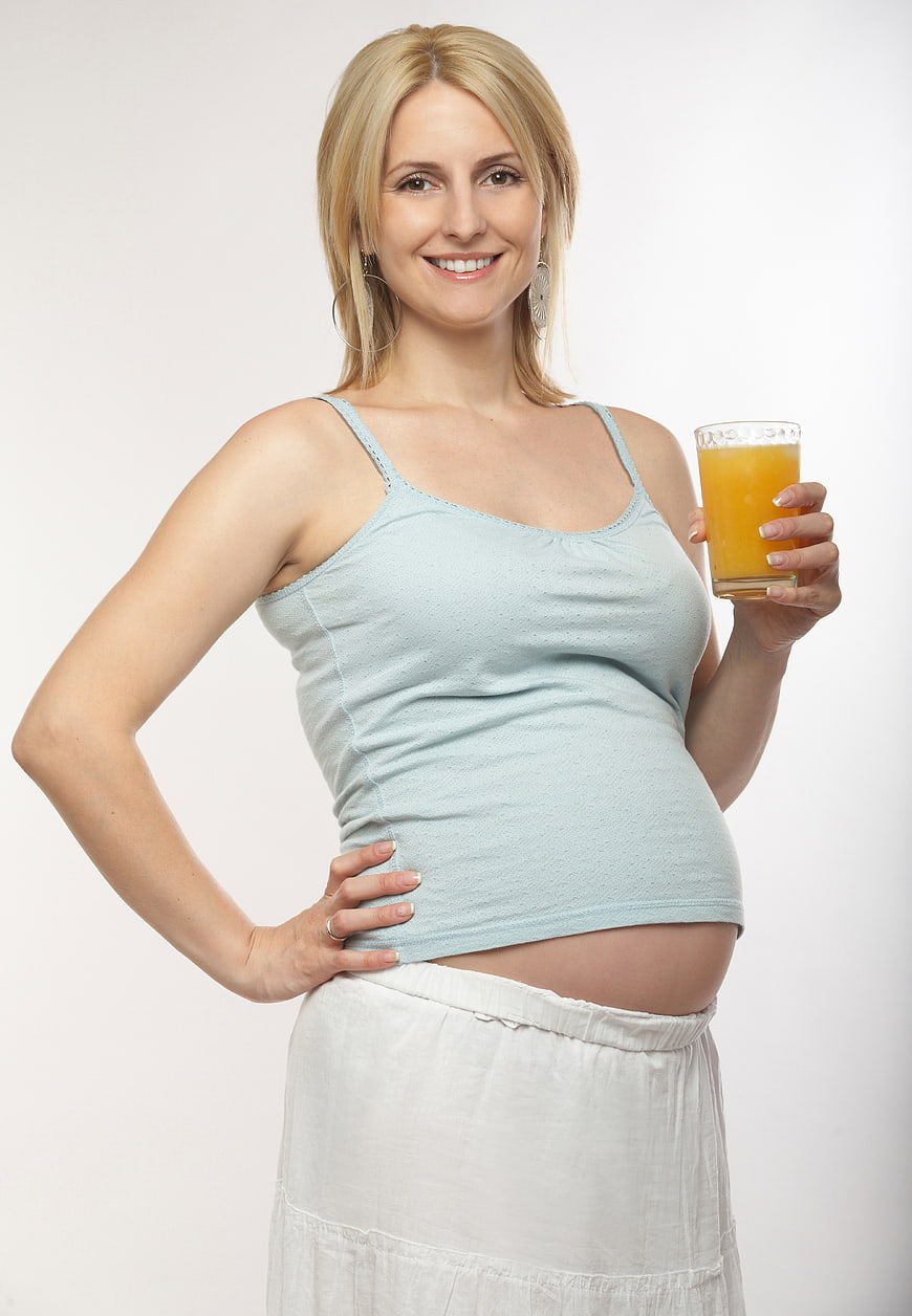 Happy Pregnant Woman Holding Glass of Orange Juice