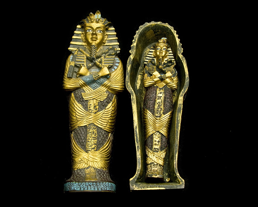 Golden Egyptian Sarcophagus and Mummy Statue Isolated on Black