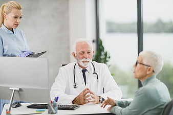 Senior Doctor Consulting with Elderly Patient and Nurse