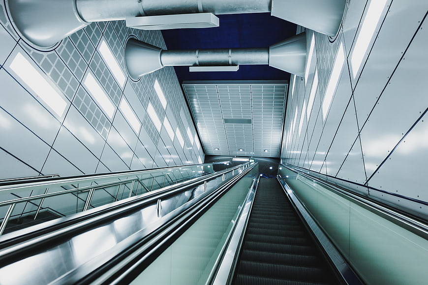 Modern escalator in futuristic subway station with blue lighting