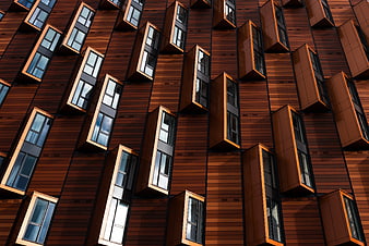 Modern brown wooden building facade with protruding windows