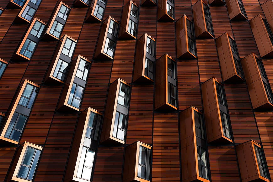 Modern brown wooden building facade with protruding windows