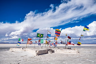 International flags on salt flat island under blue sky