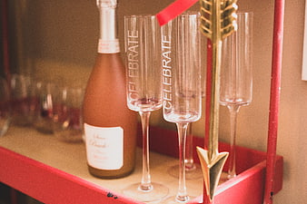 Champagne Bottle and Celebrate Glasses on Red Bar Cart