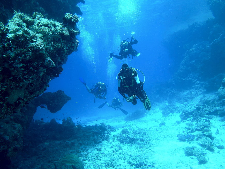 Scuba divers exploring coral reef underwater