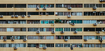 Yellow Apartment Building Facade With Air Conditioners And Windows