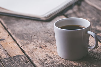 White Coffee Mug on Rustic Wooden Table with Notebook