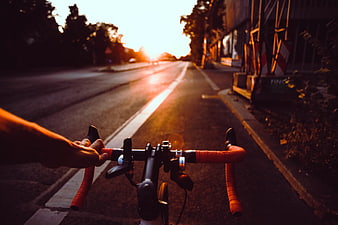 First Person View of Cycling on Road at Sunset