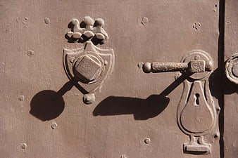 Close-up of vintage brown steel door with ornate metal latch