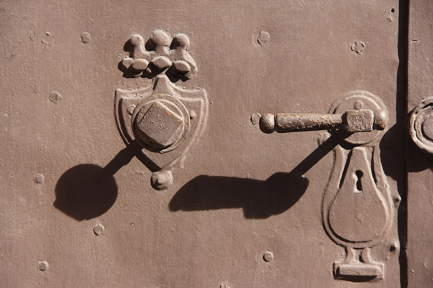 Close-up of vintage brown steel door with ornate metal latch
