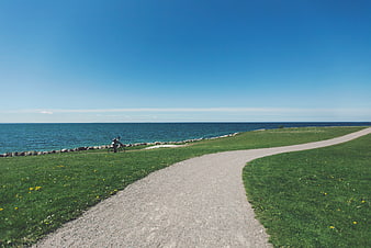 Cyclist on Gravel Path by the Sea
