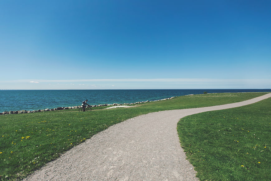Cyclist on Gravel Path by the Sea