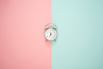 Mint Alarm Clock on Split Pastel Pink and Blue Background