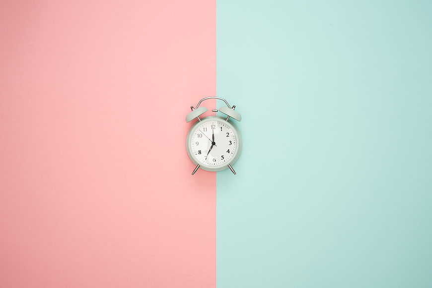 Mint Alarm Clock on Split Pastel Pink and Blue Background