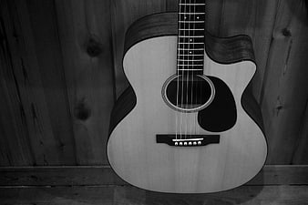 Black and white acoustic guitar on wooden wall