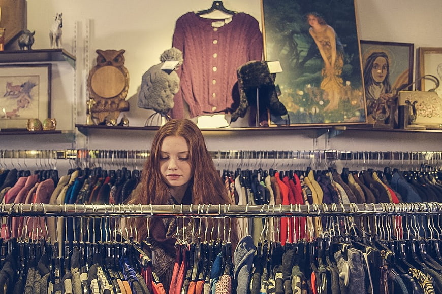Woman with red hair browsing clothes in vintage shop