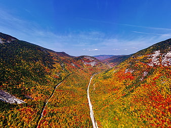 Aerial View of Winding Road Through Colorful Autumn Mountain Valley